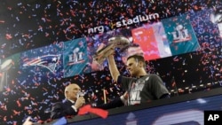 ທ້າວ Tom Brady ເປັນ quarterback ຫຼືຜູ້ນຳທີມ New England Patriots ຍົກລາງວັນຊະນະເລີດ Vince Lombardi Trophy ຂຶ້ນ ຫຼັງຈາກຍາດໄດ້ໄຊຊະນະຈາກທີມ Atlanta Falcons ໃນການແຂ່ງຂັນຊິງແຊ້ມປ້ຽນ Super Bowl ຄັ້ງທີ 51 ຂອງ ສະມາຄົມຟຸດບອລແຫ່ງຊາດ ຫຼື NFL, ວັນທີ 5 ກຸມພາ 2017.