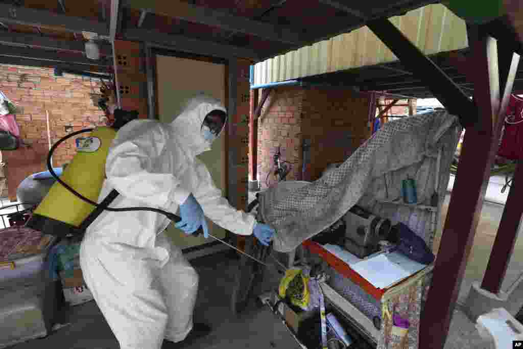 A member of the non-profit Cambodian Children&#39;s Fund sprays disinfectant to help curb the spread of the new coronavirus in the slum neighborhood of Stung Meanchey in southern Phnom Penh, Cambodia, on Tuesday, March 24, 2020. (AP Photo/Heng Sinith)