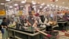Sejumlah kasir di sebuah supermarket di mal AEON, Tangerang, melayani pembeli di balik pembatas lapisan plastik untuk mencegah penularan virus corona, 22 Mei 2020. (Foto: AP)