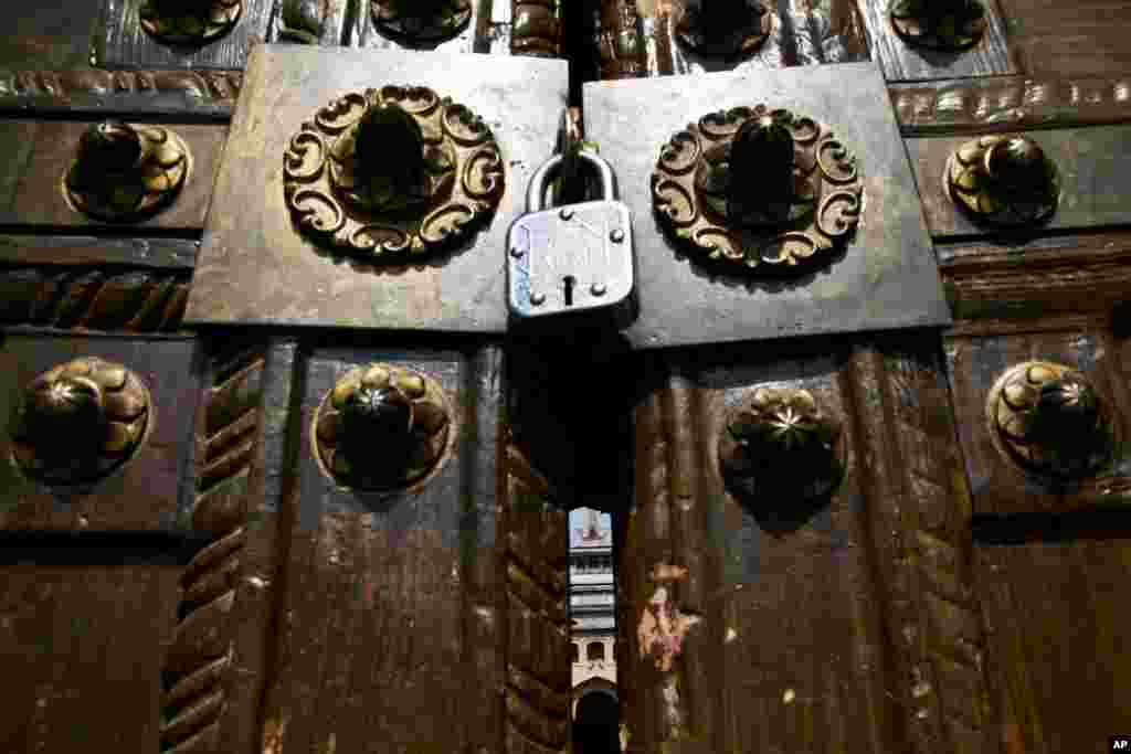 The main door of Jamia Masjid or the Grand Mosque is seen locked for the 12th consecutive Friday during a curfew in Srinagar, Indian-controlled Kashmir. Officials have ordered a curfew in parts of Srinagar to prevent a protest march and urged people to offer Friday afternoon prayers on the main roads.