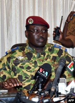 Burkina Faso's Lieutenant-Colonel Yacouba Isaac Zida (L) listens a statement is read at the end of a meeting with the country's military commanders, Nov. 1, 2014, at the military headquarters in Ouagadougou.