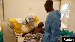 Medical staff and an Ebola survivor treat Ebola patient Ibrahim Mupalalo inside the Biosecure Emergency Care Unit at The Alliance for International Medical Action Ebola treatment center in Beni, Democratic Republic of Congo, March 31, 2019.