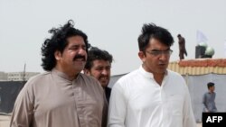 FILE - Ali Wazir, left, and Mohsin Dawar, leaders of the Pashtun Tahaffuz Movement (PTM), walk at a rally in Karachi, Pakistan, May 13, 2018.