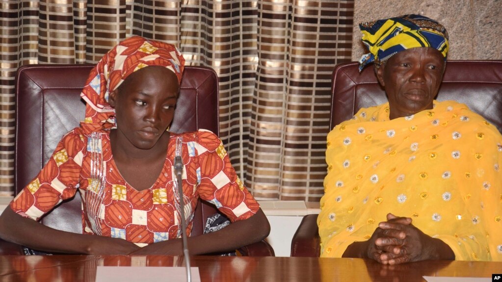 FILE - Amina Ali, left, the first rescued Chibok schoolgirl, and her mother, Binta Ali Nkeki attend a meeting with Nigeria's President Muhammadu Buhari at the Presidential palace in Abuja, Nigeria. 