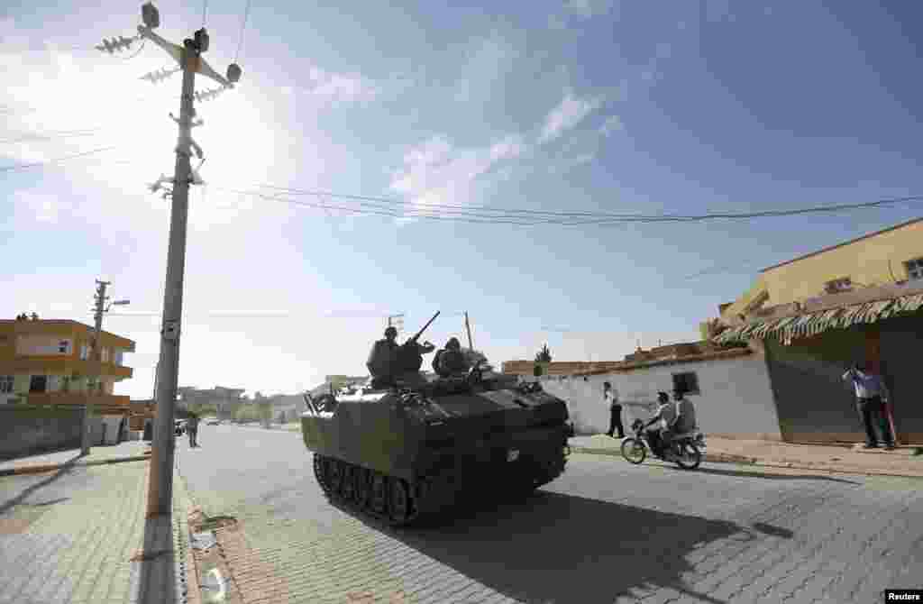 Turkish soldiers in an advanced armored personnel carrier patrol near the Akcakale border gate, on the Turkish-Syrian border, October 4, 2012. 