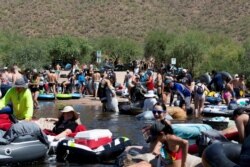 Warga bersiap untuk melakukan tubing di Salt River di tengah pandemi Covid-19 di Arizona, AS, 27 Juni 2020. (REUTERS / Cheney Orr / File Photo)