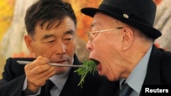 North Korean Ryu Young-il (L) feeds his South Korean father Ryu Hae-chan during their luncheon meeting, in North Korea. They were separated since the 1950-53 war, (File photo). 