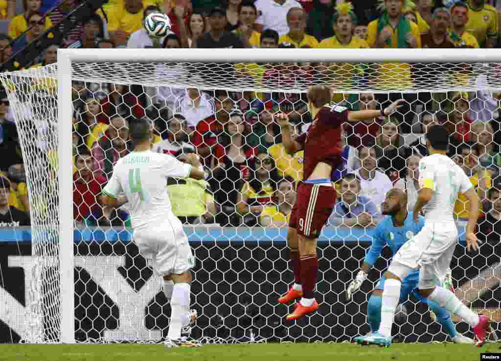 Russia&#39;s Alexander Kokorin heads the ball into the net as Algeria&#39;s Rais Mbolhi (goalkeeper), Essaid Belkalem (4) and Rafik Halliche (5) watch at the Baixada arena in Curitiba, June 26, 2014. 