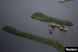 FILE - Old oil tanks are seen in an area affected by Hurricane Katrina on the Mississippi river delta, New Orleans, Louisiana, Aug. 19, 2015.