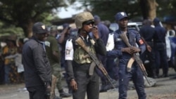 Ivory Coast policemen stand guard during a youth rally in Abidjan, Ivory Coast, 20 Dec 2010