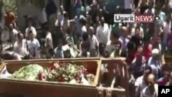Mourners carry the body of a person during a funeral ceremony in the city of Homs, Syria in this image made from amateur video released by Ugarit News, Aug. 2, 2011