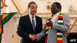 Zimbabwe President Emmerson Mnangagwa (R) and Chinese Foreign Affairs Minister Wang Yi (L) pose during their meeting at State House in Harare on January 13, 2020 as part of Wang Yi's visit to the country. (Photo by Jekesai NJIKIZANA / AFP)