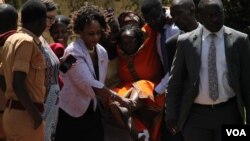 Human rights lawyer Nicholas Opio, seen (left) in this file photo carrying one of her clients, has been arrested on Dec. 22, 2020. (Photo: H. Athumani/VOA)