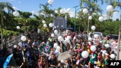 Relatives and supporters of the victims of the infamouse Maguindanao massacre, including Philippine Justice Secretary Leila de Lima (C-partly hidden), release white balloons into the air during the fifth-year anniversary commemoration at the massacre site in Ampatuan, Maguindanao province, on the southern Philippine island of Mindanao, on November 23, 2014. Senior Philippine officials vowed on November 23 to deliver justice as the nation marked the fifth anniversary of the country's worst political massacre that left 58 dead, including 32 journalists. (AFP/Mark Navales)