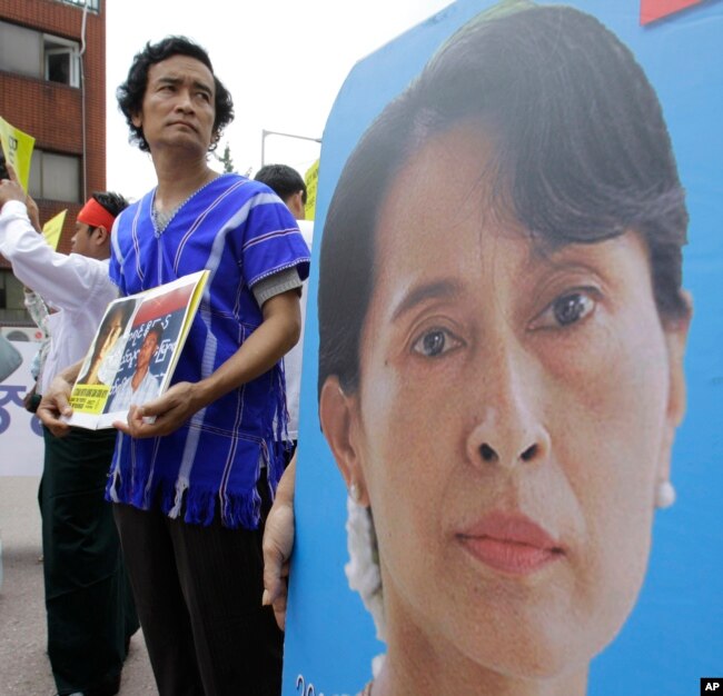 FILE - A Myanmar's activist holds a picture of their leader Aung San Suu Kyi during a rally calling for the immediate release of their pro-democracy leader Aung San Suu Kyi and her colleagues near the Myanmar Embassy in Seoul, Aug. 8, 2010.
