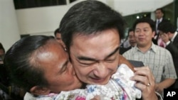 Thai Prime Minister Abhisit Vejjajiva is kissed by a supporter at his Democrat Party headquarters in Bangkok, Thailand, Nov. 29, 2010. The ruling Democrat Party survived a legal challenge Monday that could have seen it dissolved and a new government forme