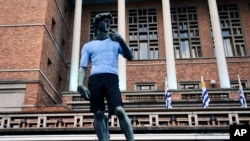 Una réplica de la estatua de Miguel Ángel David se encuentra afuera del Ayuntamiento de Montevideo vestido con la camiseta del equipo nacional de fútbol de Uruguay antes del comienzo de la transmisión televisiva del partido de la Copa Mundial Rusia 2018 entre Egipto y Uruguay