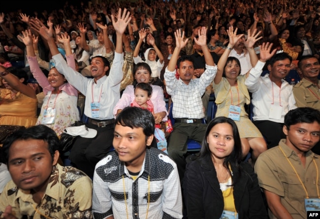 FILE - Indonesian couples gesture as they attend a mass interfaith wedding ceremony sponsored by an organizer and the Jakarta government in Jakarta on July 19, 2011.