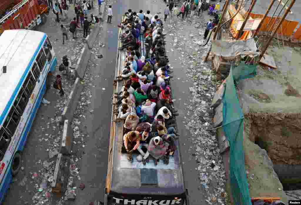 Migrant workers travel on a crowded bus as they return to their villages, during a 21-day nationwide lockdown to limit the spreading of coronavirus, in Ghaziabad, on the outskirts of New Delhi, India.