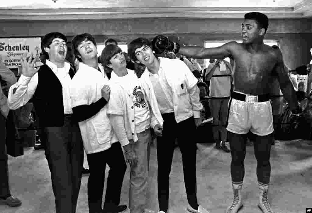 Para anggota The Beatles, dari kiri, Paul McCartney, John Lennon, Ringo Starr dan George Harrison berpura-pura mendapat tinju dari Cassius Clay, yang kemudian mengganti namanya menjadi Muhammad Ali, saat mengunjungi petinju itu di Miami Beach, Florida, 18 Februari 1964.