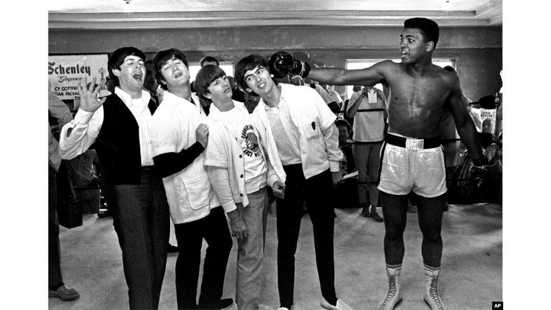 FILE - The Beatles, from left, Paul McCartney, John Lennon, Ringo Starr and George Harrison take a fake blow from Cassius Clay, who later changed his name to Muhammad Ali, while visiting the heavyweight contender in Miami Beach, Fla., Feb. 18, 1964.