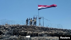 Syrian forces of President Bashar al Assad are seen celebrating on al-Haara hill in Quneitra area, recaptured from rebels and IS militants, July 17, 2018.