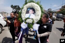 Cambodian community activists carry a wreath during the funeral procession of government critic Kem Ley, pictured, in Phnom Penh, Cambodia, July 11, 2016.