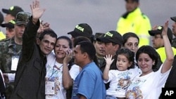 Carlos Jose Duarte, a Colombian policeman recently freed by FARC rebels, waves at the media with his relatives as he arrives at Villavicencio's airport April 2, 2012. 