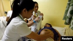 Seorang petugas memeriksa seorang ibu yang hamil. Pendidikan reproduksi konvensional di Indonesia lebih dititikberatkan pada kaum perempuan (foto: ilustrasi). 