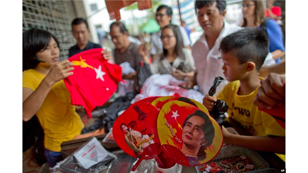 People gather to buy merchandise with pictures of Myanmar opposition leader Aung San Suu Kyi at a shop run by her National League of Democracy party in Yangon, Myanmar, Nov. 10, 2015. Her party accused the government of delaying eleciton results.