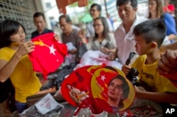People gather to buy merchandise with pictures of Myanmar opposition leader Aung San Suu Kyi at a shop run by her National League of Democracy party in Yangon, Myanmar, Nov. 10, 2015. Her party accused the government of delaying eleciton results.