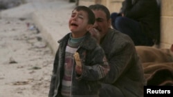 A boy cries at a site hit by what activists say was an airstrike by forces loyal to Syrian President Bashar al-Assad in Masaken Hanano in Aleppo, Feb. 14, 2014.