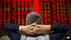一位中國投資者9月16日在北京一處證券交易所觀察股市走向。