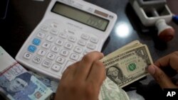 Lembaran uang dolar AS tengah dihitung oleh seorang petugas di sebuah tempat penukaran uang di Islamabad, Pakistan, pada 17 Mei 2019. (Foto: AP/B. K. Bangash)