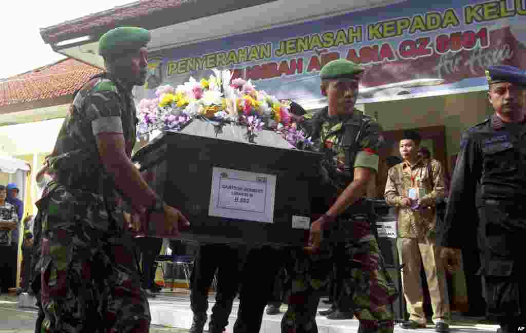 Tentara Indonesia mengangkat peti jenazah salah seorang korban AirAsia QZ8501 Grayson Herbert Linaksita, saat serah terima jenazah kepada keluarga korban di rumah sakit polisi Surabaya, Jawa Timur (2/1).