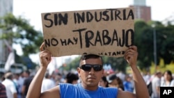 A demonstrator holds a sign that reads in Spanish "Without industry there is no work" during a labor march in Buenos Aires, March 7, 2017. 
