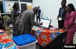 FILE - A man practices using an electronic voting machine during a demonstration inside Congo's electoral commission (CENI) head offices in Gombe Municipality of Kinshasa, Democratic Republic of the Congo, March 1, 2018.