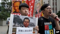 Pro-democracy activists carry a picture of visiting top Chinese official, Zhang Dejiang, along with images of detained Chinese dissidents, as they march to the Government House where a dinner is held for Zhang in Hong Kong, May 17, 2016.