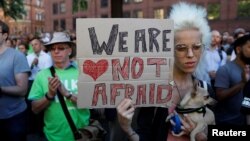 A woman holds a placard as they take part in a vigil for the victims of an attack on concert goers at Manchester Arena, in central Manchester, Britain, May 23, 2017.