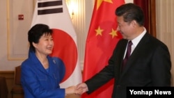지난 4월 미국 워싱턴에서 열린 핵안보정상회의에 참석한 박근혜 한국 대통령(왼쪽)과 시진핑 중국 국가주석이 개별 정상회담에 앞서 악수하고 있다.