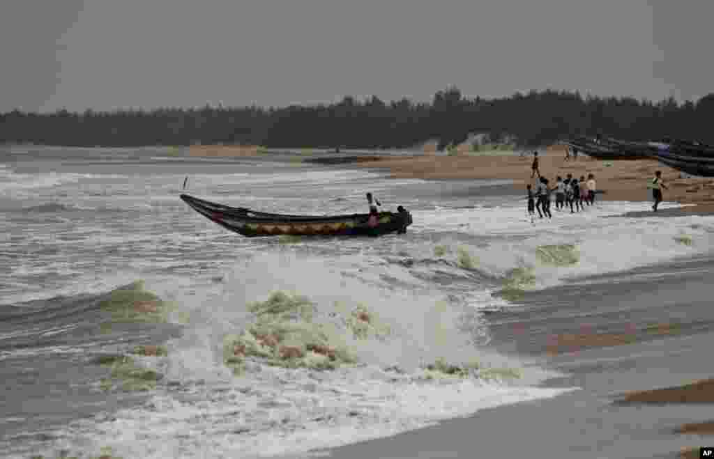 Fishermen pull out a boat as a cyclone approaches from the Bay of Bengal at Gokhurkuda, India, Oct. 11, 2013.