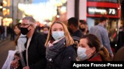 Shoppers, some wearing face coverings, cross Oxford Street in central London on Dec. 4, 2021, as compulsory mask wearing in shops has been reintroduced in England as fears rise over the Omicron variant of Covid-19. 