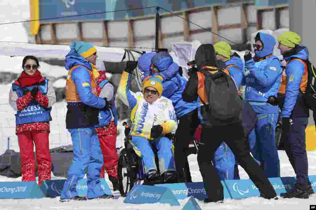 Anggota tim Ukraina merayakan rekan mereka yang menjadi juara satu dan ketiga dalam nomor Biathlon untuk Tunanetra Putra 7,5 kilomenter di Alpensia Biathlon Center di Paralimpiade Musim Dingin 2018, di&nbsp; Pyeongchang, Korea Utara, 10 Maret 2018.