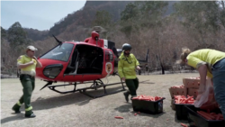 Rescue workers load helicopter with food for rock wallabies near Newnes, New South Wales, Australia