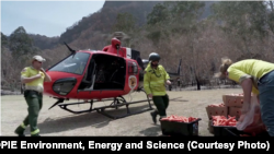Rescue workers load helicopter with food for rock wallabies near Newnes, New South Wales, Australia
