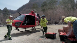 Rescue workers load helicopter with food for rock wallabies near Newnes, New South Wales, Australia