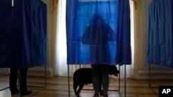 A woman fills her ballot at a polling station during the presidential election in Kiev, Ukraine, Sunday, March 31, 2019. (AP Photo/Efrem Lukatsky)