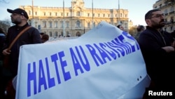 FILE - People attend a gathering, organized by the CRIF Jewish organization, in memory of Mireille Knoll, an 85-year-old Holocaust survivor stabbed and burned in her Paris apartment in what authorities treated as an anti-Semitic slaying, in Marseille, France, March 28, 2018. The banner reads "Stop racism." 