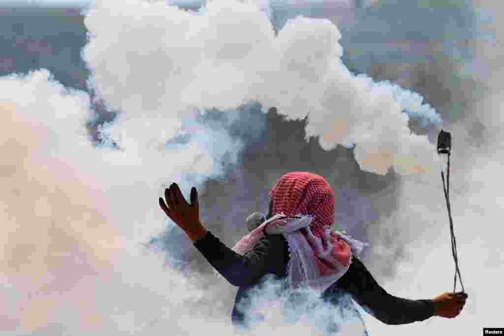 A Palestinian uses a sling as demonstrators clash with Israeli forces during a protest against Israeli settlements, in Beita, in the Israeli-occupied West Bank.