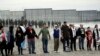 People hold hands in prayer during a protest in San Diego, near the border with Tijuana, Mexico, Dec. 10, 2018.